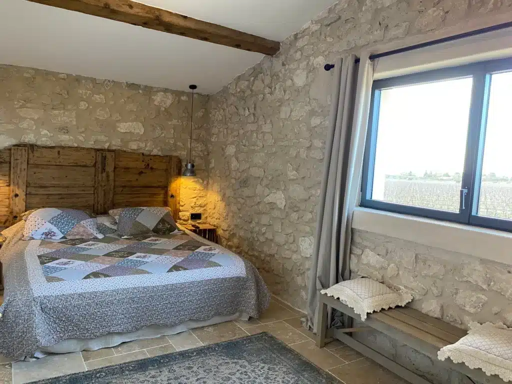 Chambre du Gite des Hautes Vignes avec lit double et fenetre ouvrant sur une vue sur les vignes